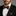Man wearing a black suit with a white shirt and leopard print bow tie and pocket square.