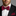 Man wearing a black suit with a red and black patterned bow tie and pocket square.