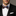 Man wearing a black suit with a colorful bow tie against a neutral background