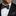 Man wearing suit with green, red and yellow paisley bow tie and square