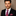 Man wearing a black suit with a Pink, Purple Snowflakes Necktie & Accenting Square against a beige background