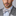 Man wearing a gray suit with a patterned bow tie and pocket square on a gray background