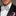 Man wearing a black tuxedo with a white bow tie featuring black polka dots.