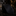 Black textured tie on a dark surface with blurred background