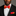 Man wearing a black suit with a red and yellow bow tie and pocket square against a gray background