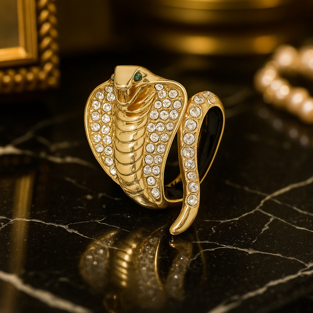Gold snake-shaped brooch with gemstones on a black marble surface