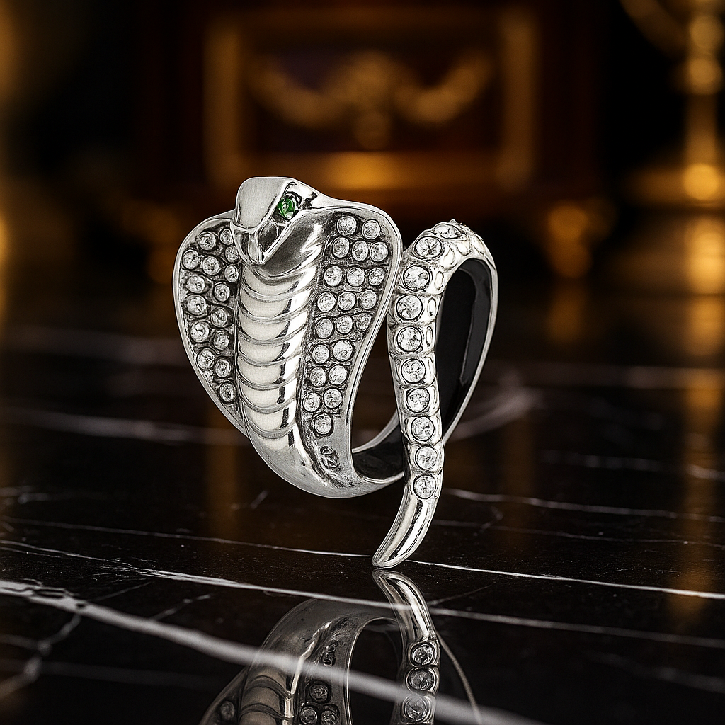Silver snake-shaped ring with gemstones on a reflective surface