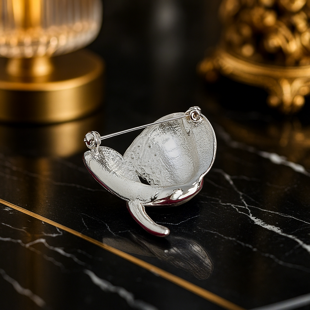 Silver brooch with a clear stone on a dark surface