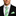 Man wearing a black suit with a green plaid tie and matching pocket square.