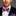 Man wearing a black suit with a colorful bow tie and pocket square on a gray background