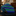 Folded green and blue striped tie on a dark surface with a blurred background
