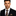 Man wearing a black suit with a colorful tie and pocket square on a white background