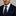 Man wearing blue suit and blue with brown necktie and matching square