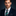Man wearing blue suit with green plaid tie and accenting square
