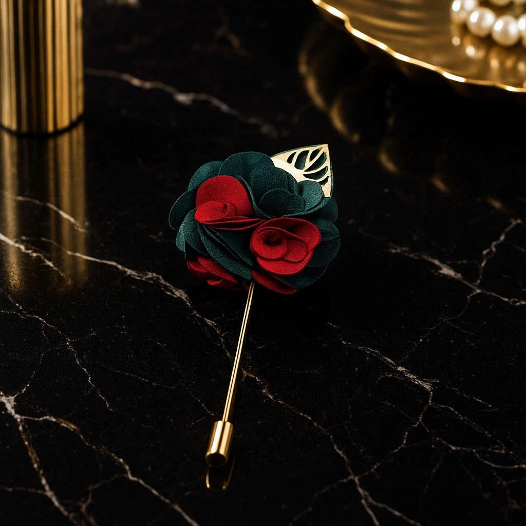 Floral lapel pin with red and green roses on a black marble surface