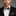 Man wearing a black suit with a colorful bow tie and pocket square against a gray background