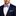 Man wearing a navy suit with a white shirt, purple checkered bow tie, and matching pocket square.