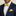 Man wearing a navy suit with a yellow bow tie and pocket square against a neutral background