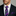Man wearing a dark suit with a purple striped tie and matching pocket square.