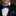 Man wearing a black suit with a blue bow tie and matching pocket square.