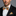 Man wearing a black suit with an orange and blue checkered bow tie and pocket square.