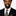 Man wearing a black suit with a patterned tie on a white background