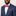 Man wearing a blue suit with a red patterned bow tie and pocket square on a plain background