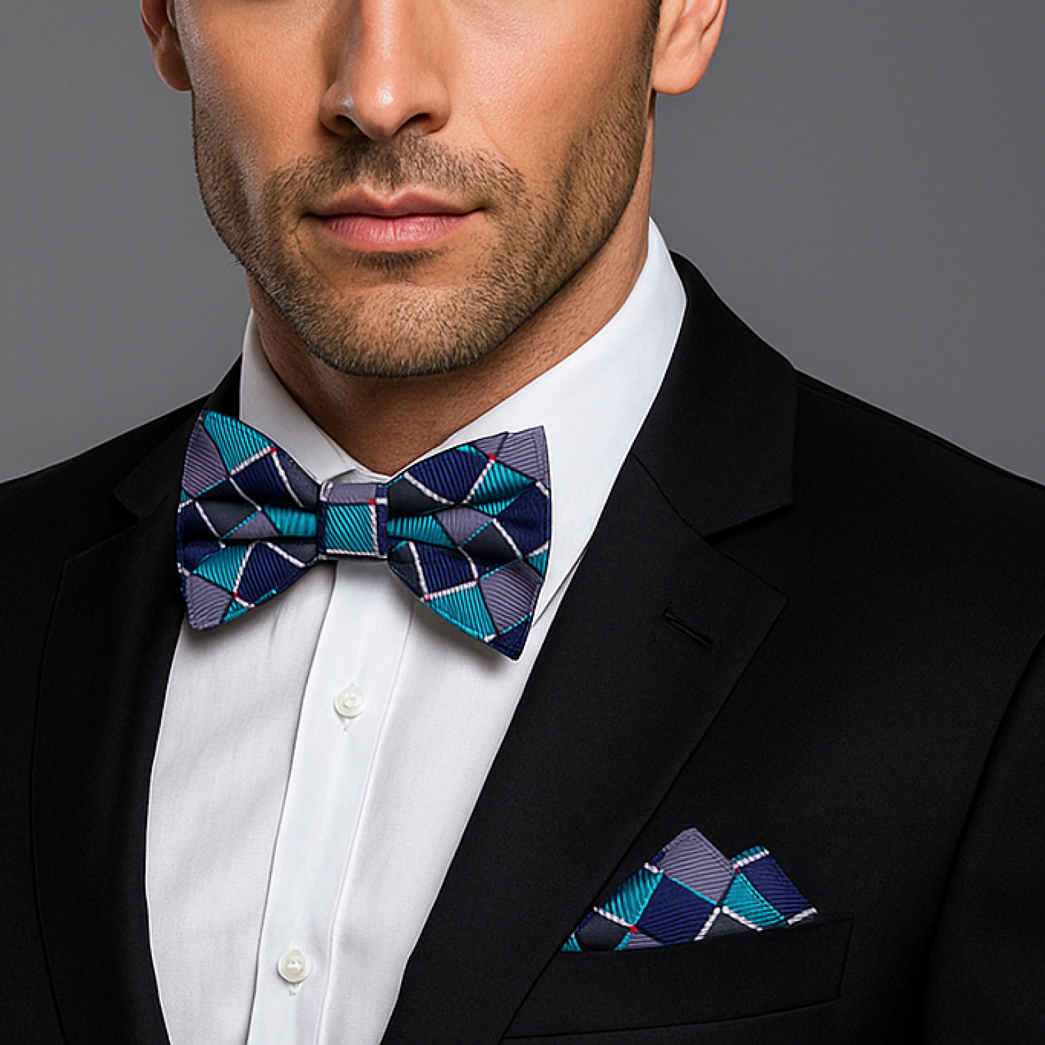 Man wearing a black suit with a blue and purple patterned bow tie and pocket square.