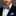 Man wearing a black suit with a blue geometric bow tie and pocket square.
