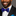 Man wearing a black suit with a white shirt and blue paisley bow tie, smiling.