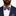 Man wearing a navy suit with a pink and purple leaf-patterned bow tie and pocket square.