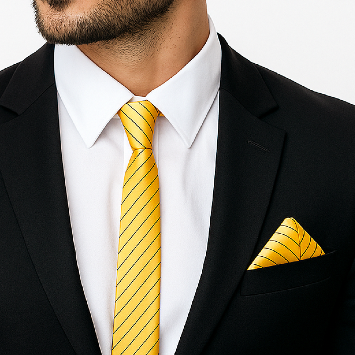 Man wearing a black suit with a yellow striped tie and matching pocket square.
