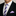 Man wearing a black suit with a white shirt, purple striped thin tie, and light purple pocket square.