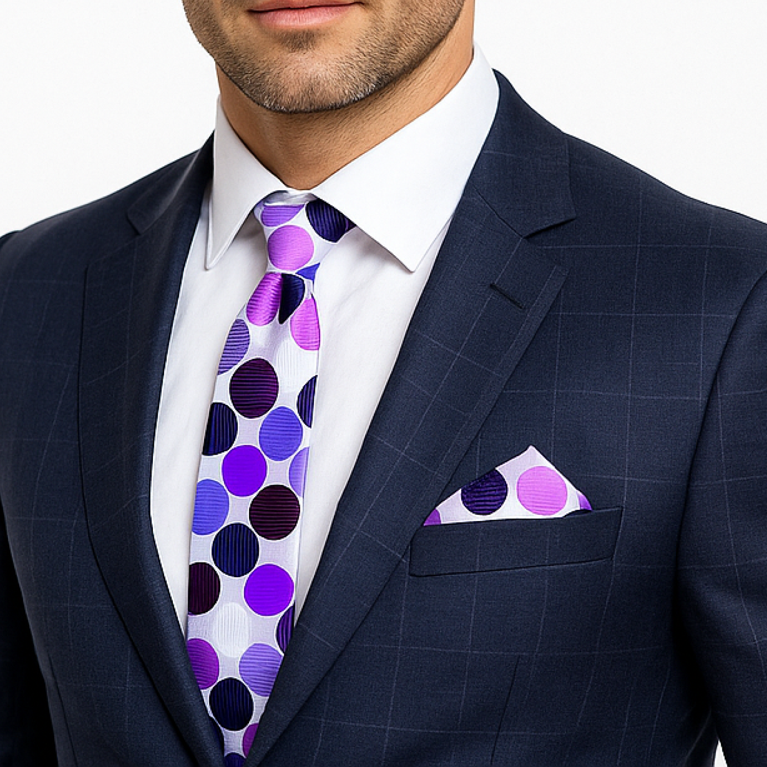 Man wearing a navy suit with a white shirt, purple polka dot tie, and matching pocket square.