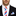 Man wearing a black suit with a white shirt, red and blue striped tie, and matching pocket square.