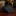 Black patterned tie on a dark surface with blurred background