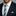 Man wearing a navy suit with a white shirt, green and blue striped tie, and matching pocket square.