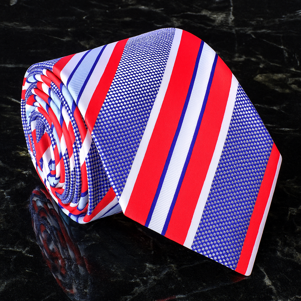 Striped tie with red, white, and blue pattern on a reflective black surface