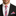 Man wearing a black suit with a red, white, and blue striped tie and pocket square.