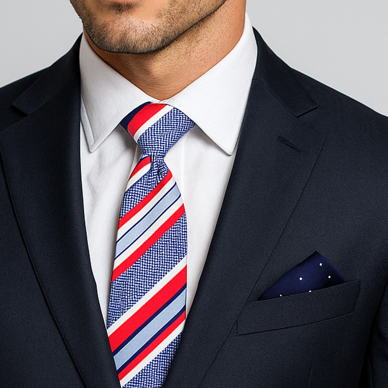Man wearing a navy suit with a colorful striped tie and blue white dot square
