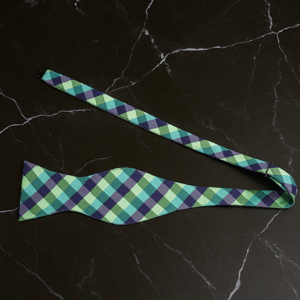 Green and blue plaid bow tie on a black marble background