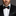 Man wearing a black suit with a Black, Red, Yellow and Grey Plaid Bow Tie and Pocket Square.