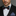 Man wearing a black suit with a Black, Red, Yellow and Grey Plaid Bow Tie and Accenting Pocket Square