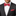 Man wearing a black suit with a red plaid bow tie and pocket square on a white background