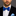 Man wearing a black suit with a blue geometric patterned bow tie and pocket square.