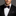 Man wearing a black tuxedo with a red geometric bow tie and accenting pocket square.