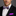 Man wearing a black suit with a purple plaid bow tie and matching pocket square.