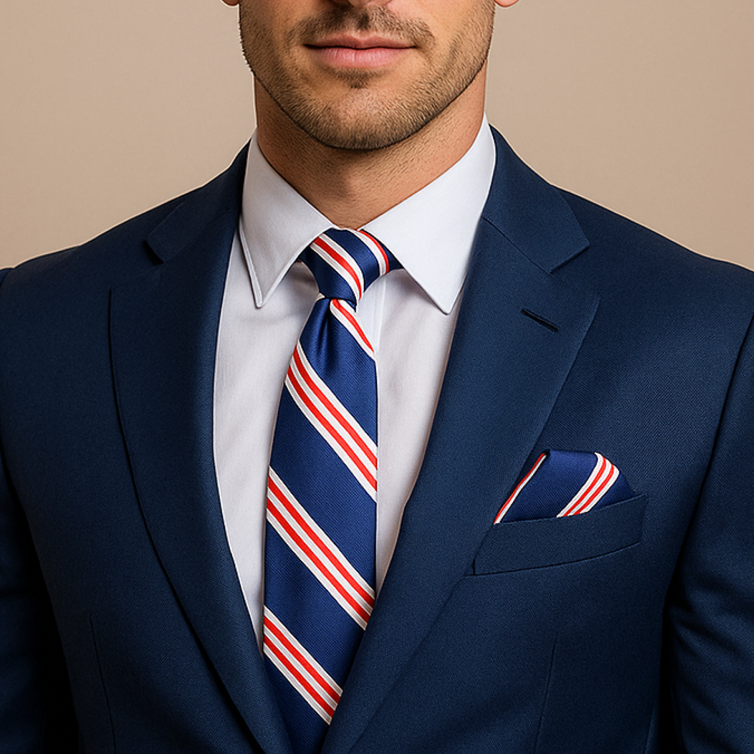 Man wearing a navy suit with a striped tie and pocket square on a beige background