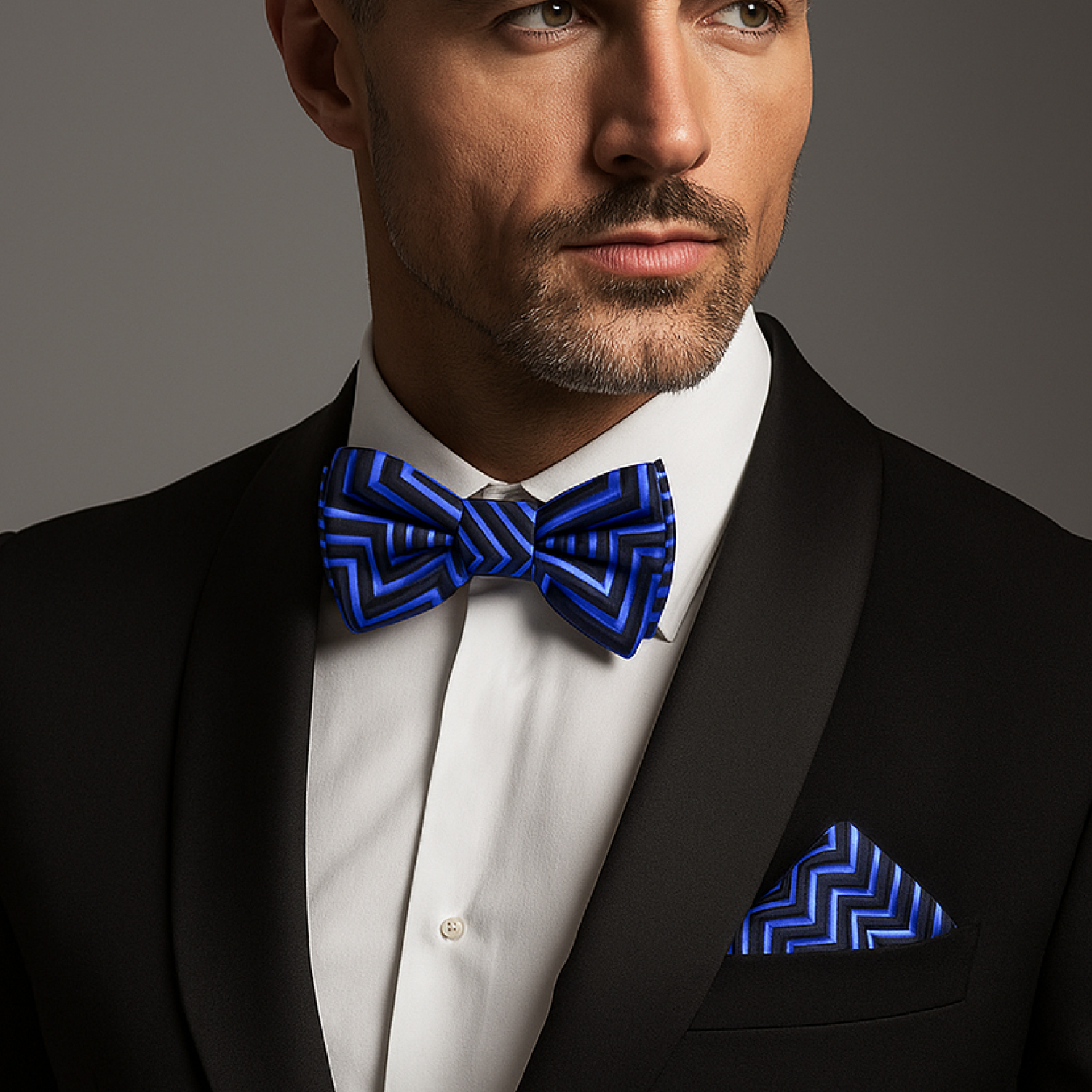 Man wearing blue and black lined bow tie and square on nice black suit
