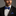 Man wearing blue and black lined bow tie and square on nice black suit
